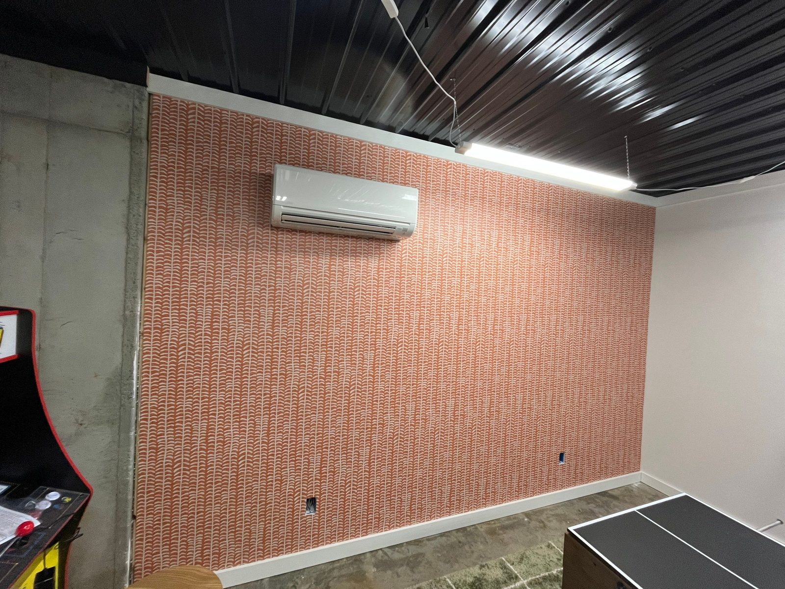 Patterned wallpaper accent wall going up in the Morganton cabin game room, mid-project