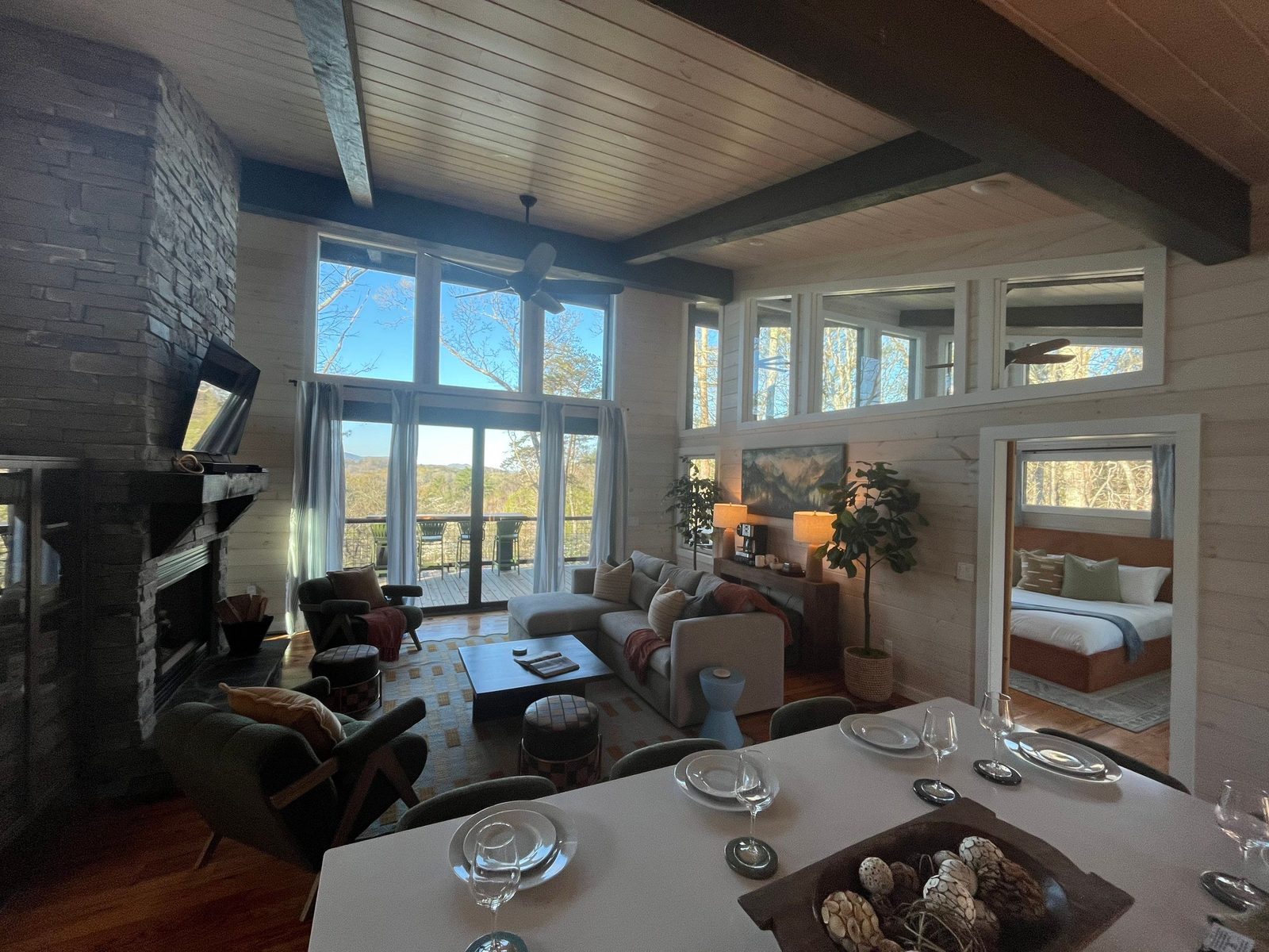 Staged Airbnb cabin living room with stone fireplace and mountain views