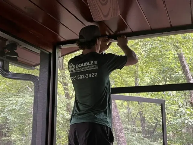 Double R crew member installing new fiberglass screen on a cabin porch panel in Blue Ridge, GA