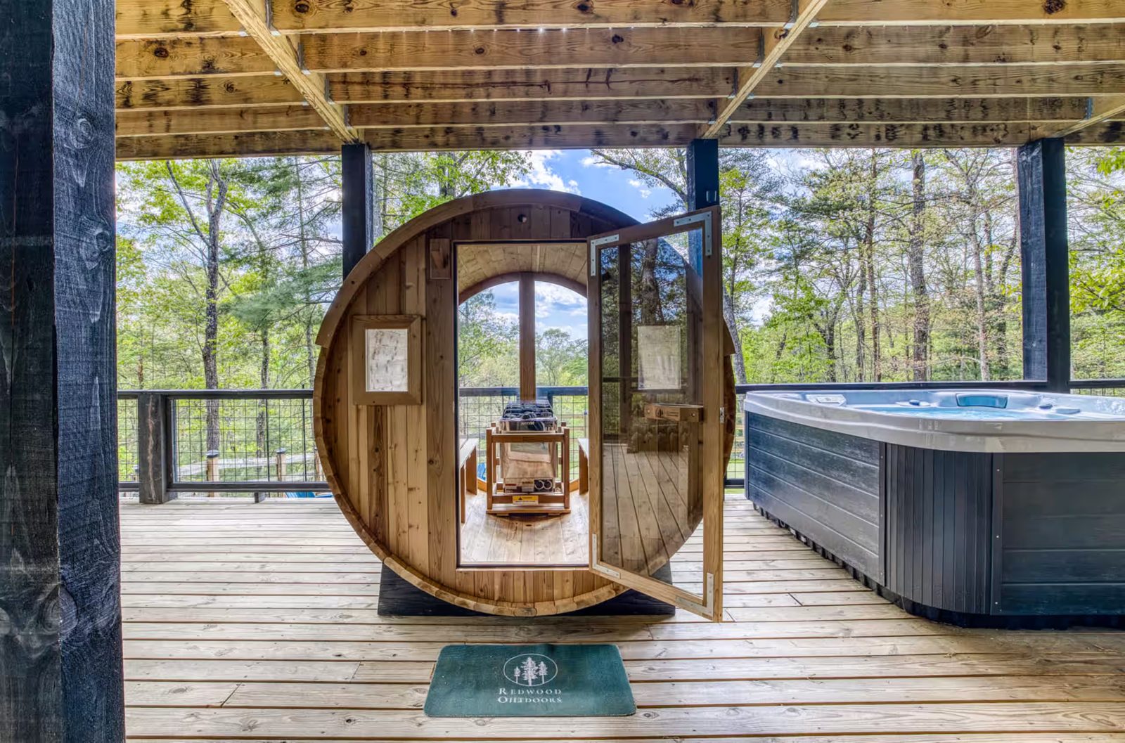 Barrel sauna installed beside a hot tub on a covered North Georgia cabin deck