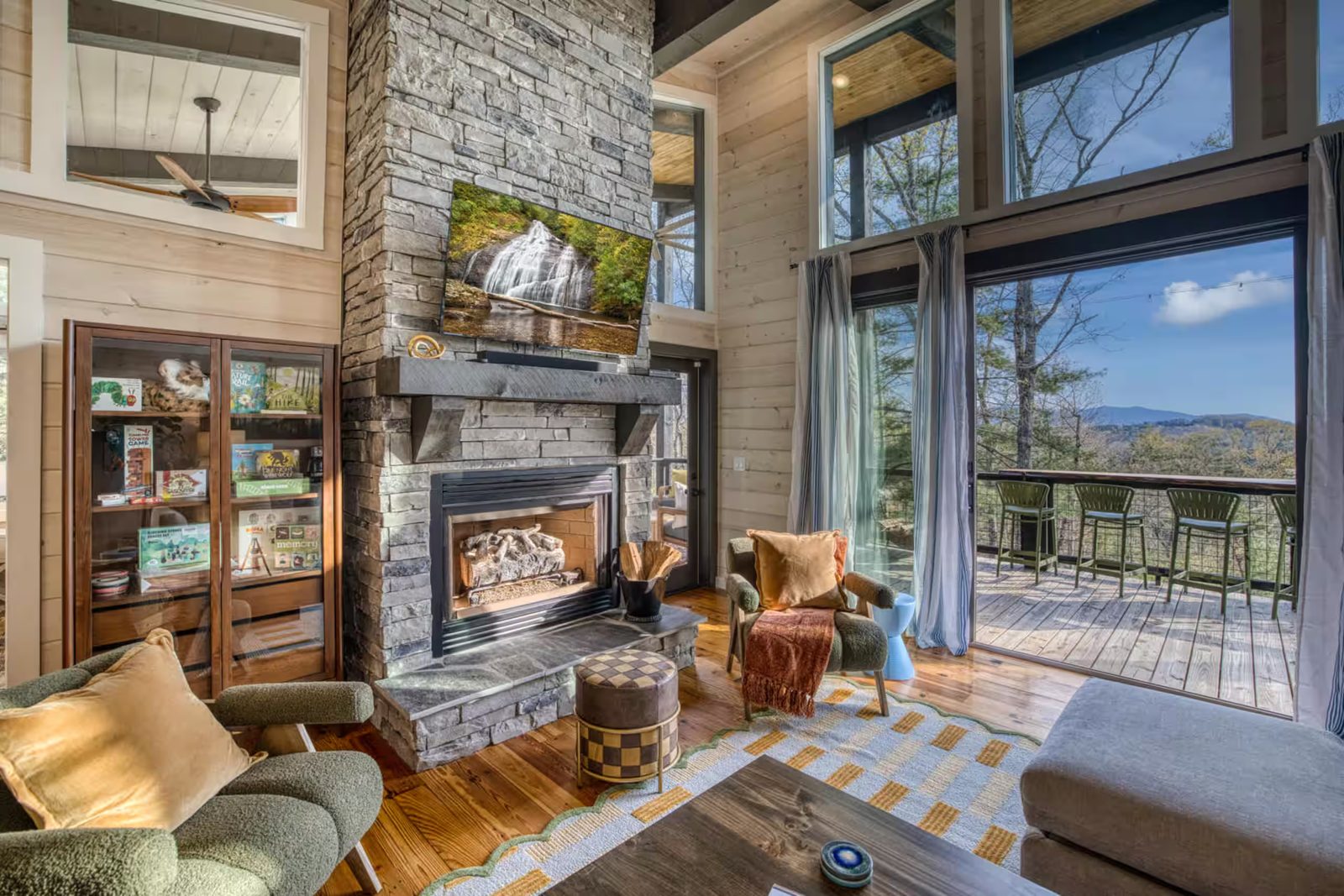 Stacked-stone fireplace against whitewashed pine walls in a Morganton cabin living room