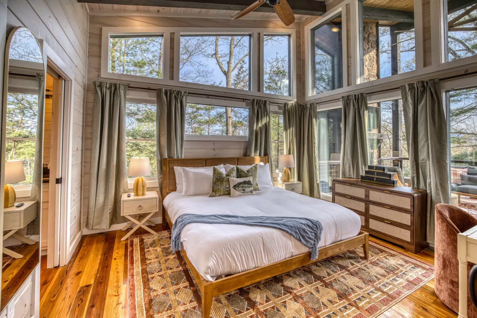 Whitewashed pine bedroom with window walls in a Morganton Airbnb cabin