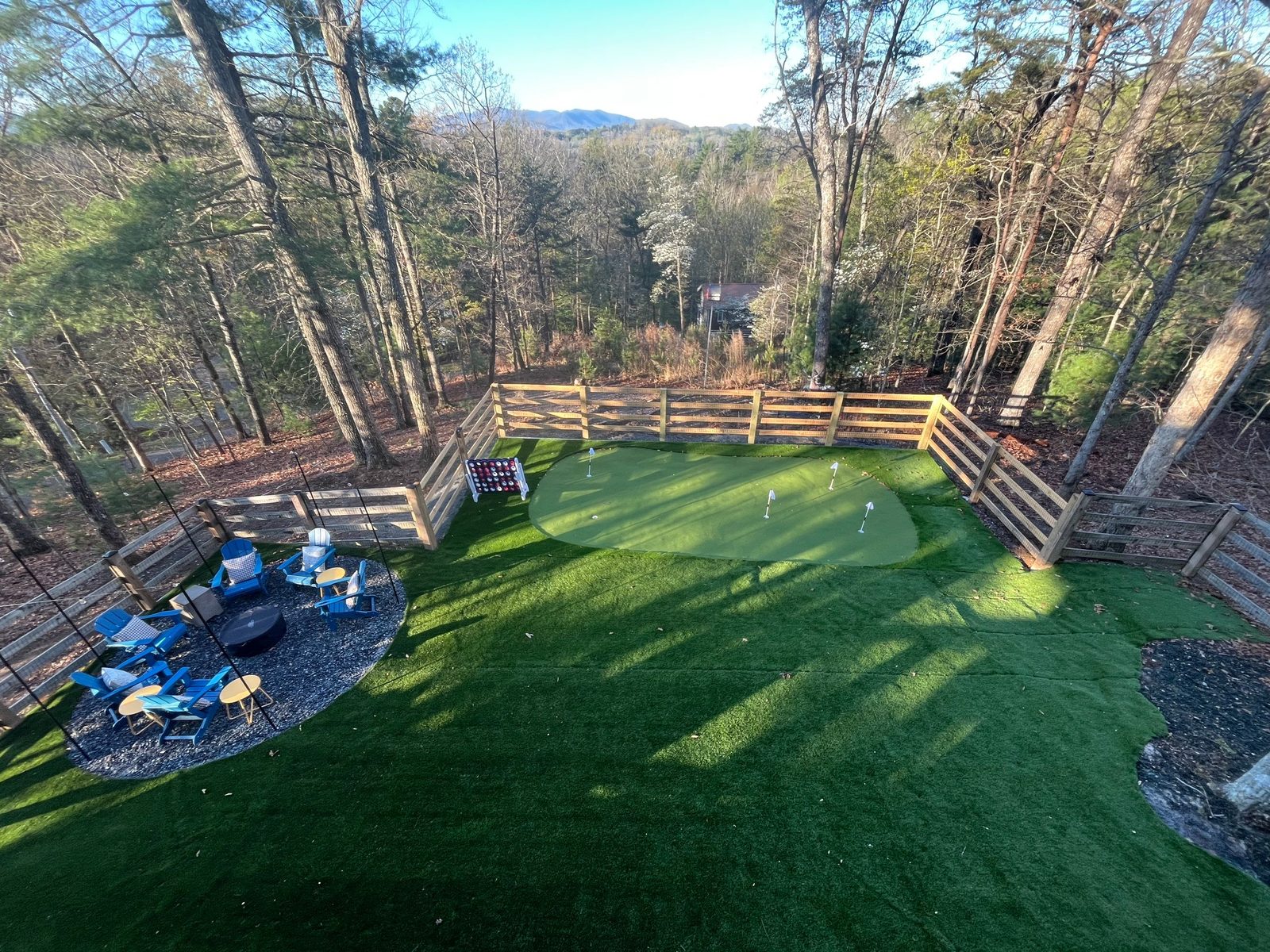Putting green and fire pit seating area behind a North Georgia rental cabin