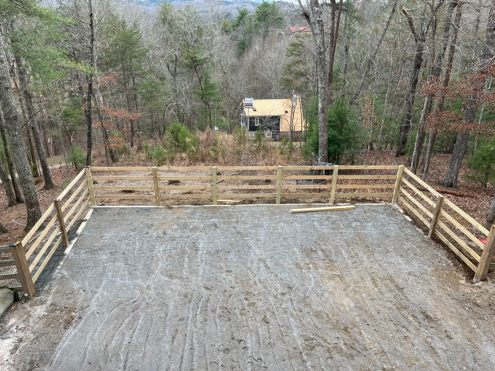 Graded and fenced backyard pad prepared for a putting green install in North Georgia