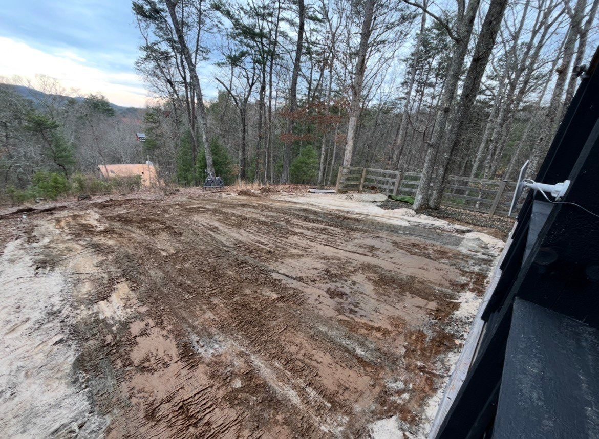 Leveled dirt pad graded for artificial turf at a North Georgia cabin